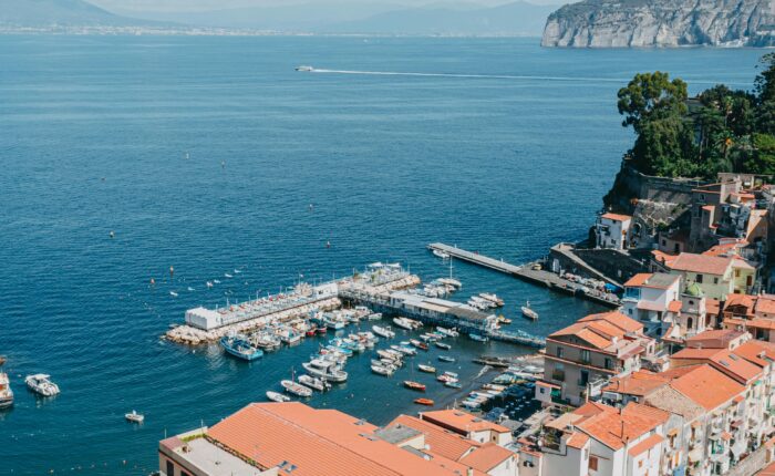 Aerial view of Marina Grande in Sorrento with traditional boats and colorful coastal buildings.